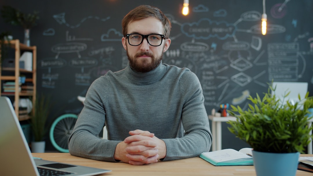 Man with glasses sitting at desk in office