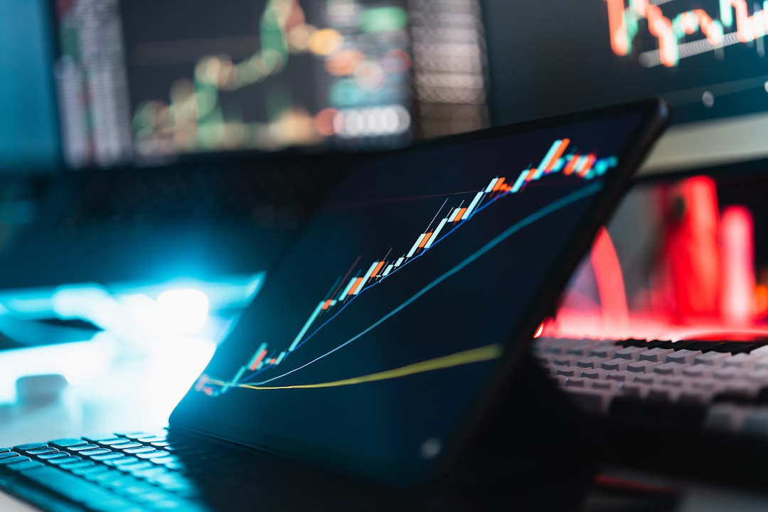 A tablet displaying a rising stock market graph on a desk with a keyboard